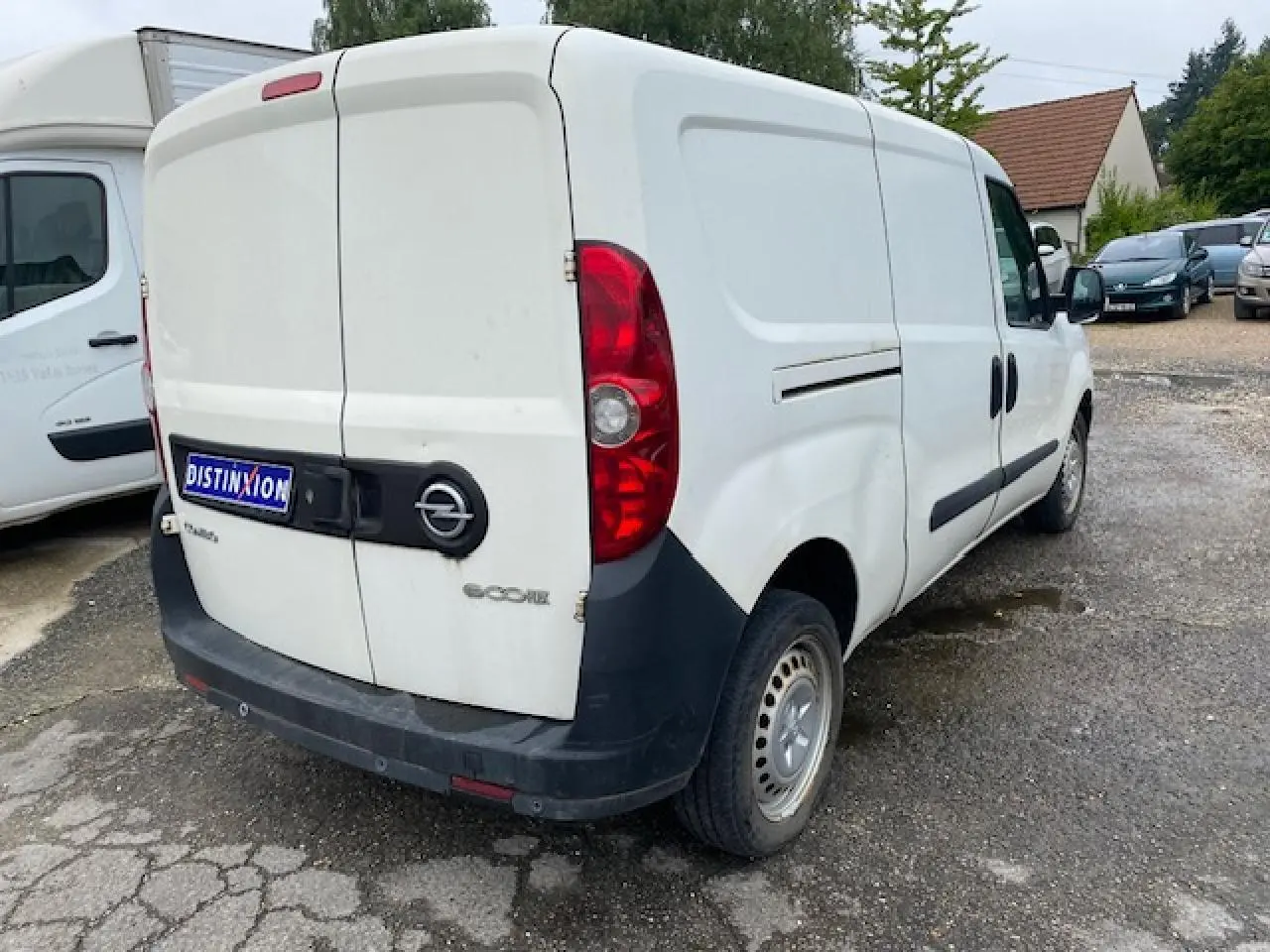 Vue 3/4 arrière droite d'un utilitaire Opel Combo blanc avec portes arrière tôlées et porte latérale coulissante.