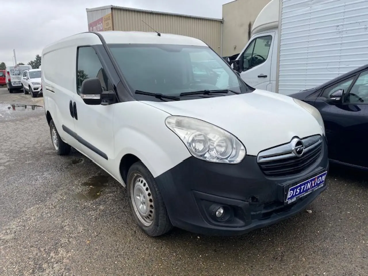 Vue 3/4 avant d’un Opel Combo blanc avec pare-chocs noir et porte latérale droite coulissante tôlée.