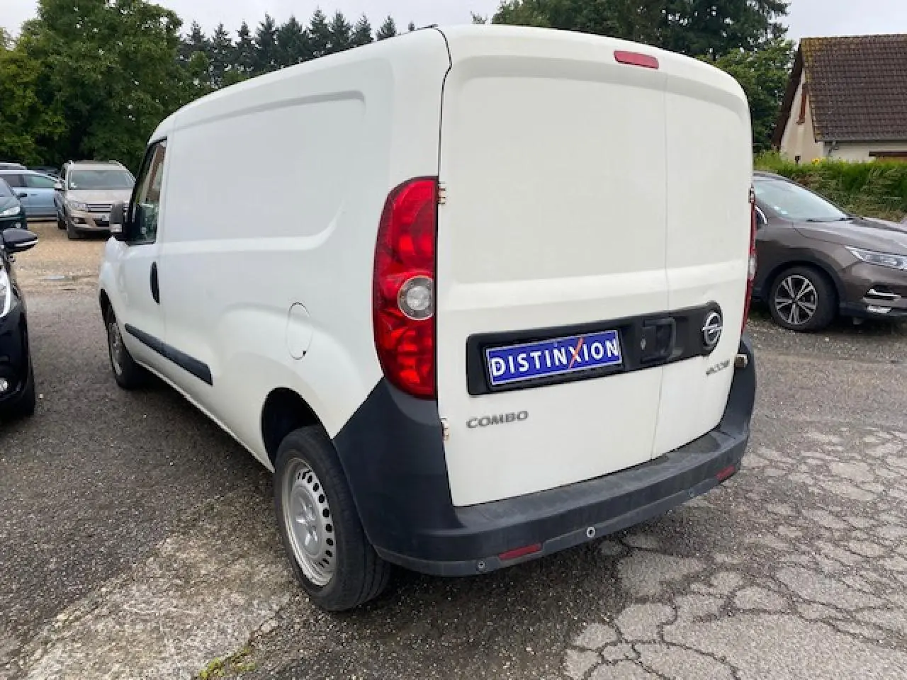 Vue 3/4 arrière droite d’un utilitaire Opel Combo blanc avec portes arrière tôlées et porte latérale coulissante.