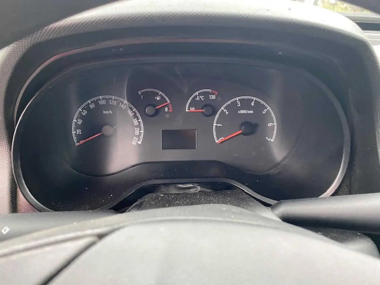 Vue rapprochée du tableau de bord noir de l'Opel Combo blanc, affichant compteurs vitesse, carburant et température.