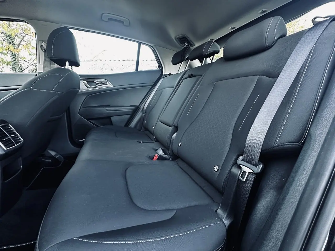 Banquette arrière noire vue côté droit du Kia Sportage 2023 avec ceintures et appuie-têtes intégrés.
