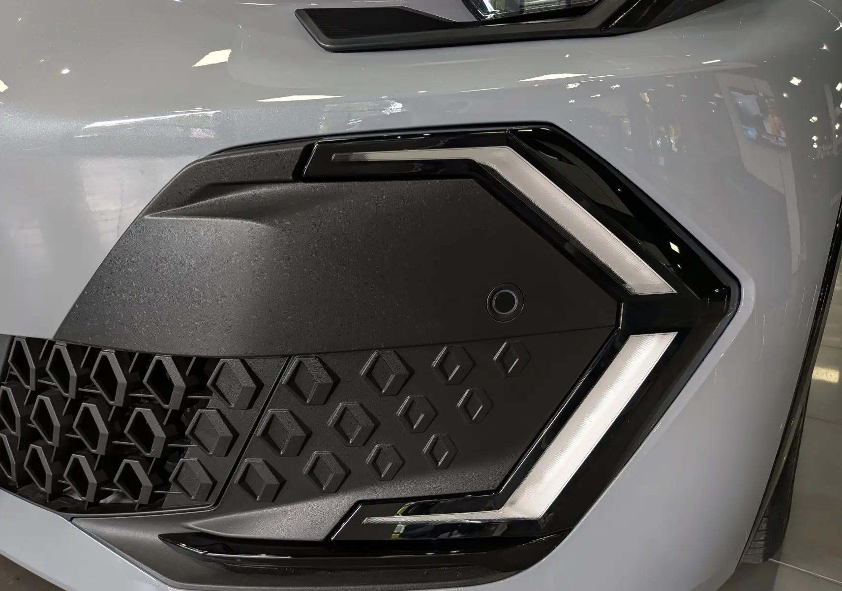 Gros plan sur le phare avant droit gris Rafale de la Renault Clio VI TCe 115 TECHNO avec signature lumineuse en forme de flèche.