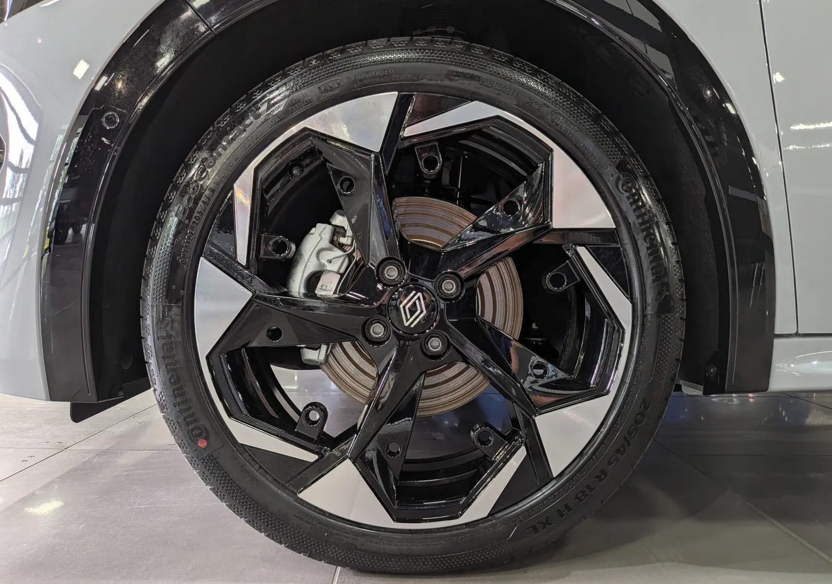 Gros plan sur la jante avant droite bicolore noire et argentée de la Renault Clio VI Gris Rafale 2026.