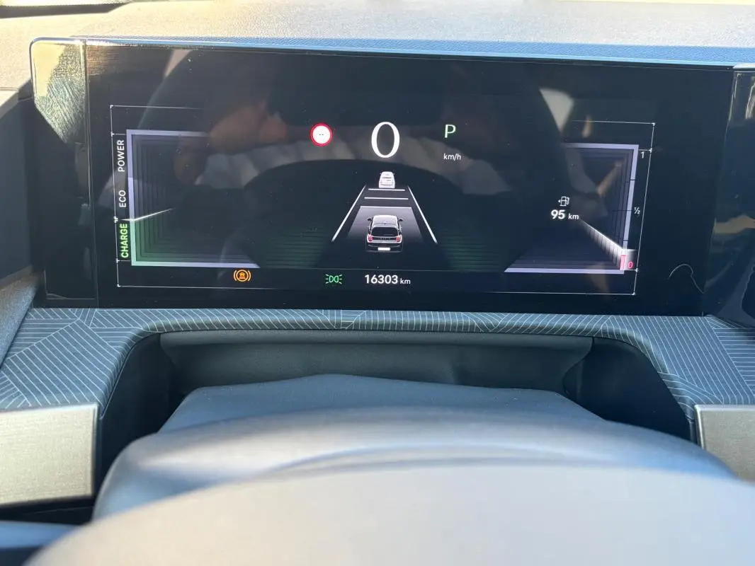 Vue rapprochée du tableau de bord numérique de la Lancia Ypsilon gris, affichant la vitesse et l'autonomie restante.