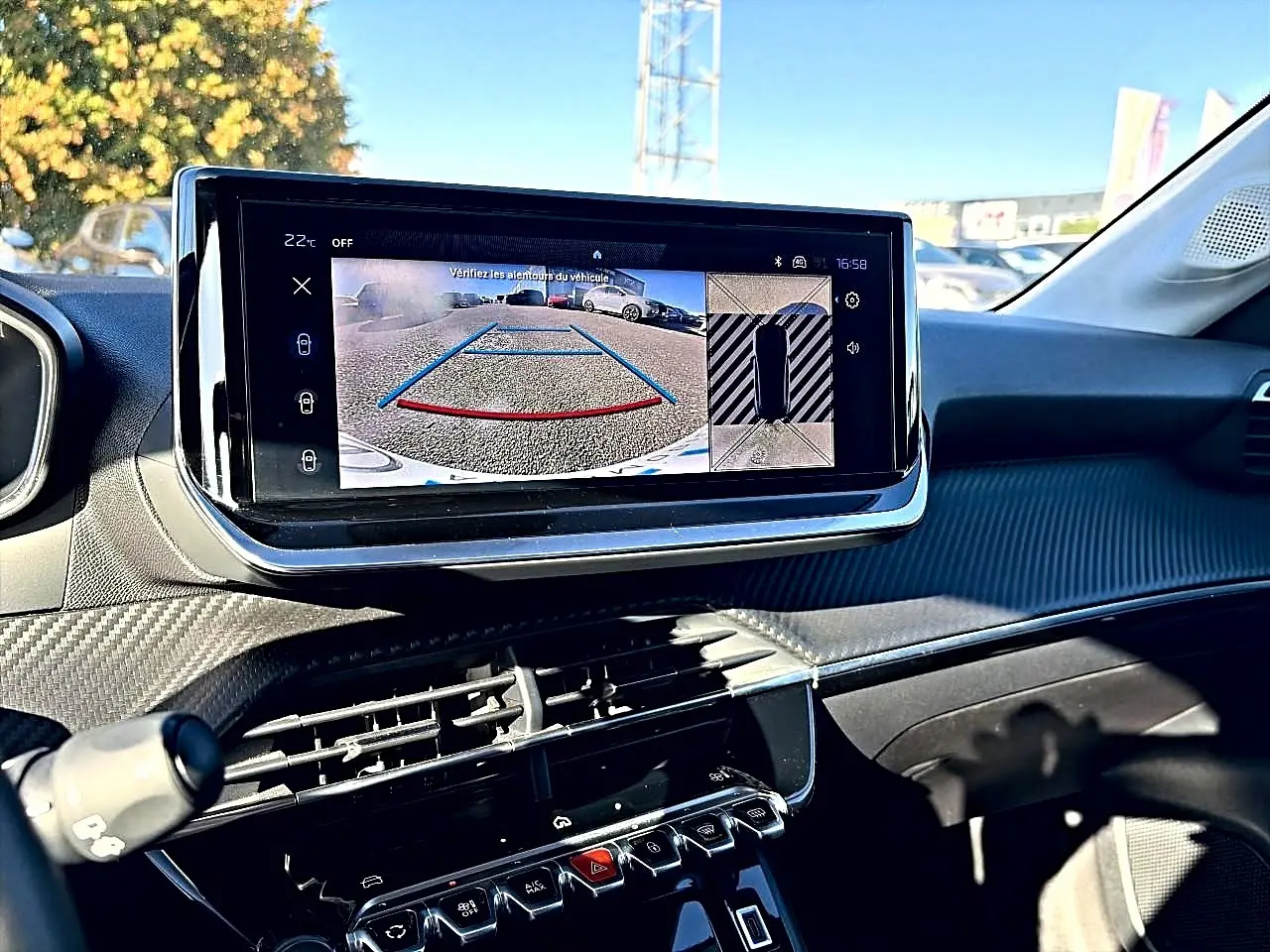Vue intérieure du tableau de bord de la Peugeot 208 1.2 100 Allure avec écran tactile affichant la caméra de recul.