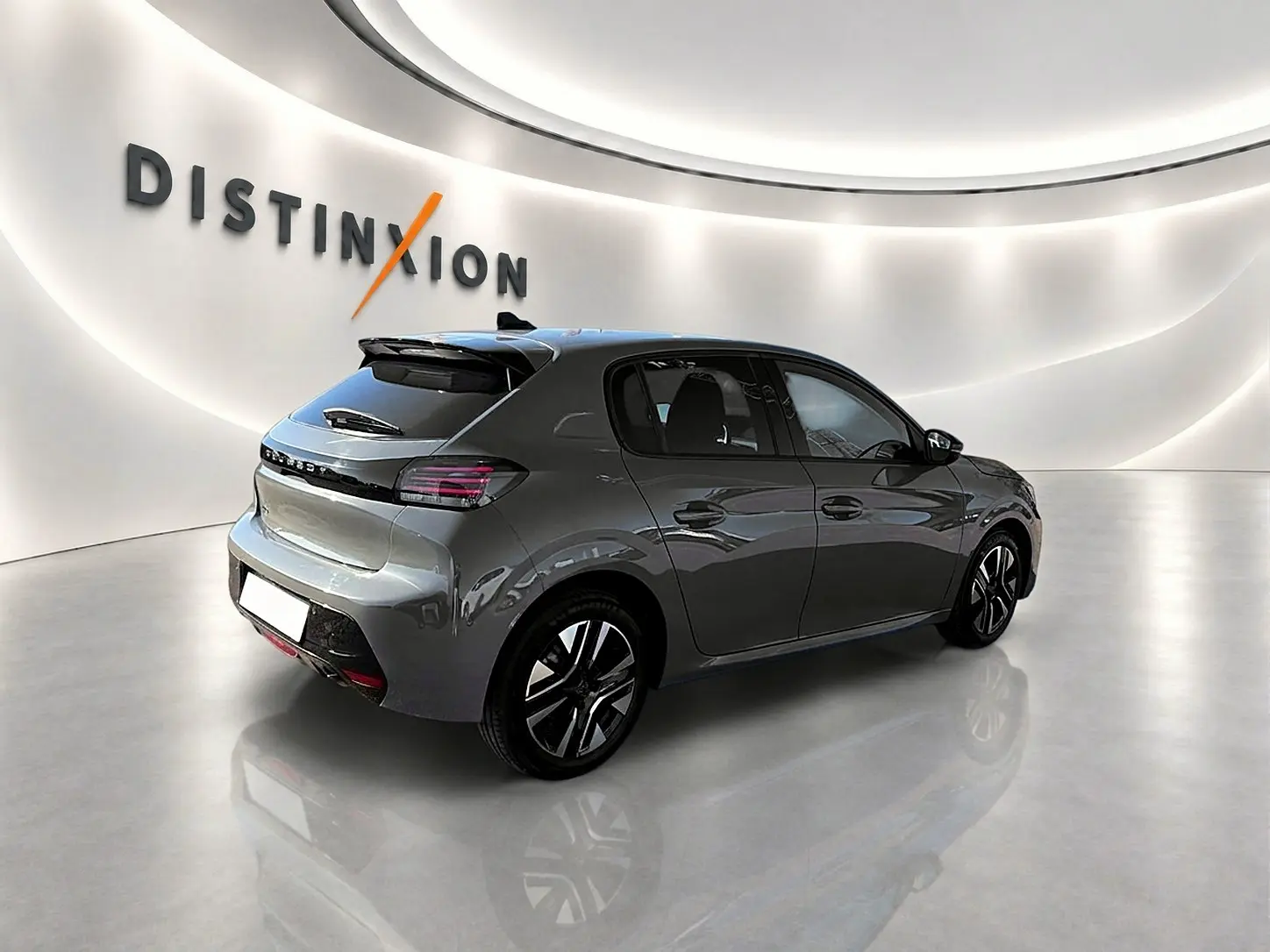 Peugeot 208 gris selenium vue 3/4 arrière droit en showroom avec jantes alu et feux arrière LED.