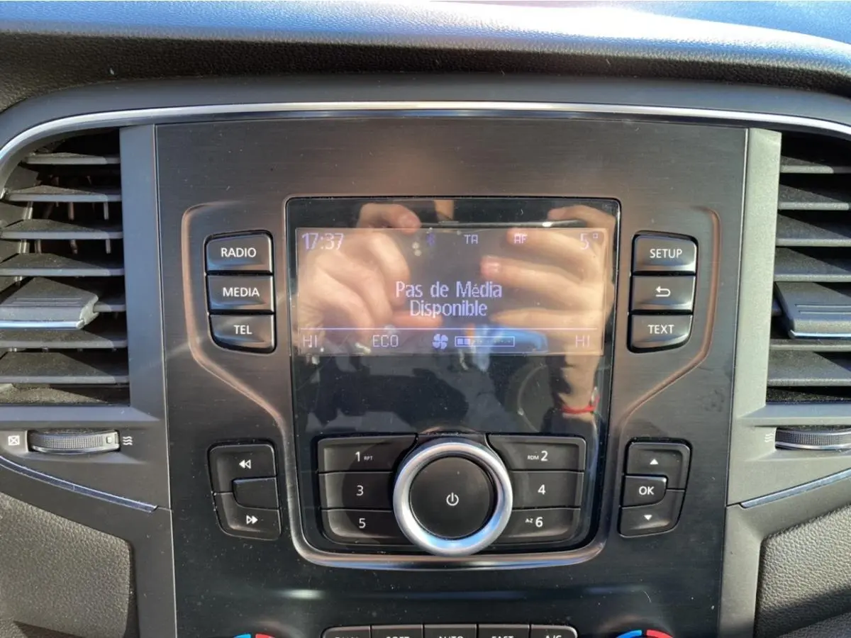 Tableau de bord central de Renault Mégane gris platine 2017 avec écran multifonction affichant "Pas de Média Disponible" et commandes autour.