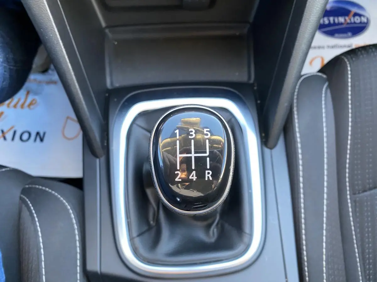 Le levier de vitesses manuel noir de la Renault Mégane gris platine, vu de dessus, avec coutures blanches sur les sièges.