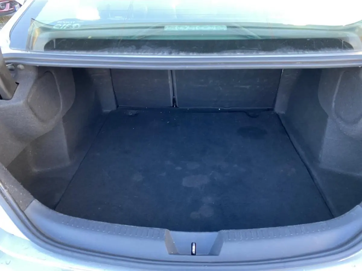 Vue plongeante sur le coffre vide d'une Renault Mégane Sedan gris platine, soulignant son espace de rangement.