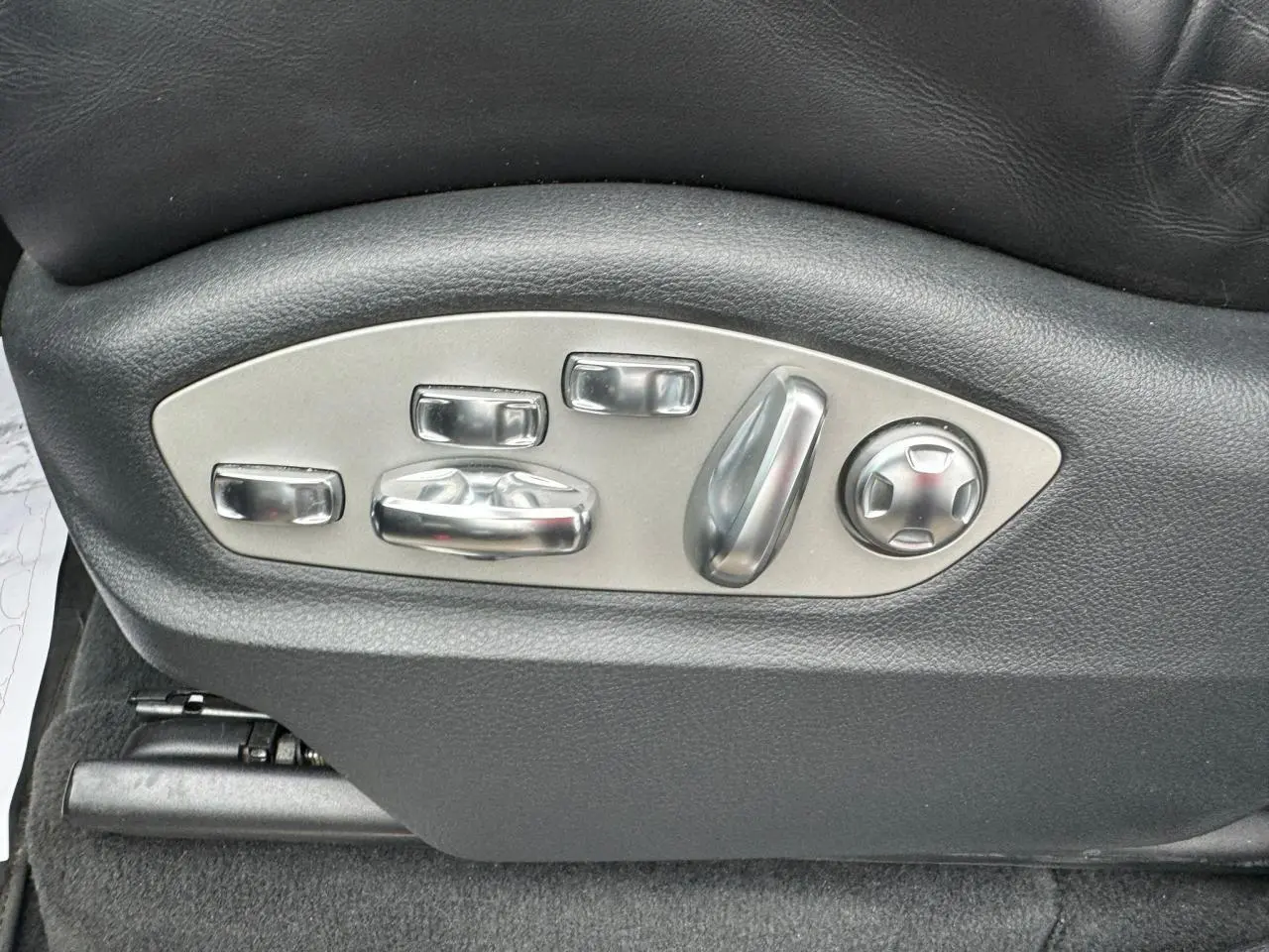 Gros plan sur les commandes de réglage électrique du siège en cuir noir d'un Porsche Cayenne S E-Hybrid 2017.