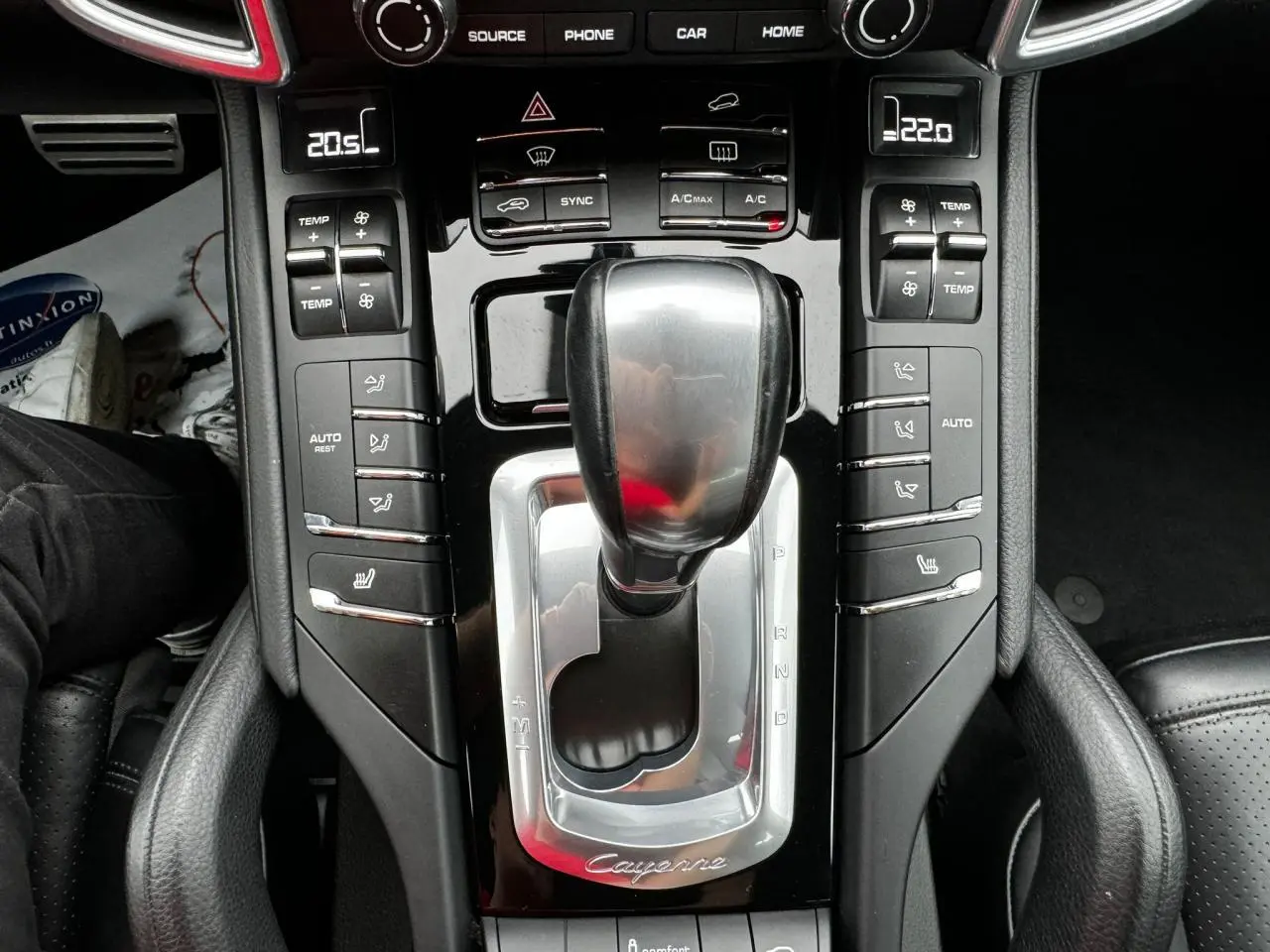 Vue rapprochée de la console centrale noire du Porsche Cayenne 2017 avec levier de vitesses automatique et commandes climatisation.