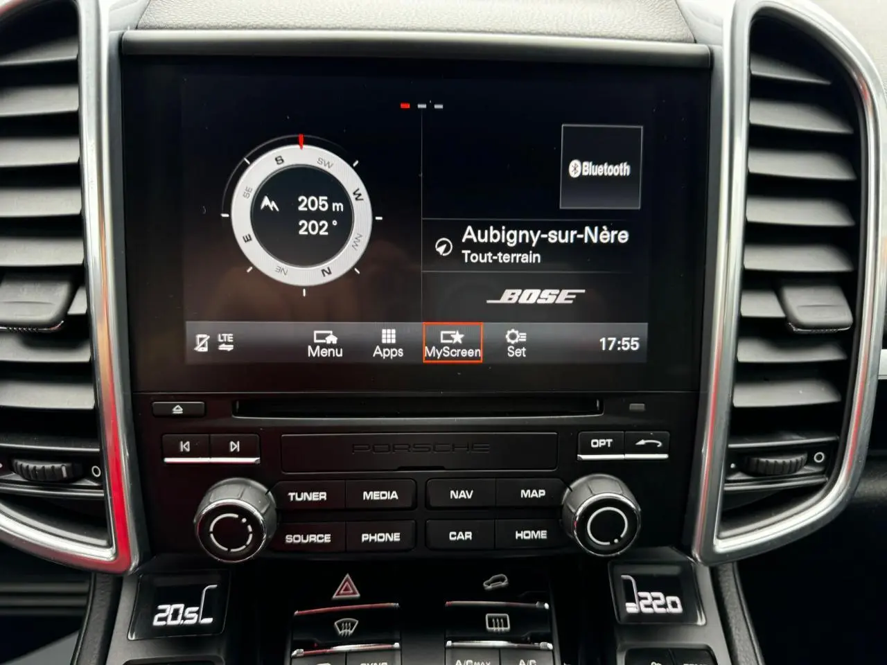 Vue rapprochée du tableau de bord du Porsche Cayenne noir 2017 avec écran central affichant navigation et son Bose.