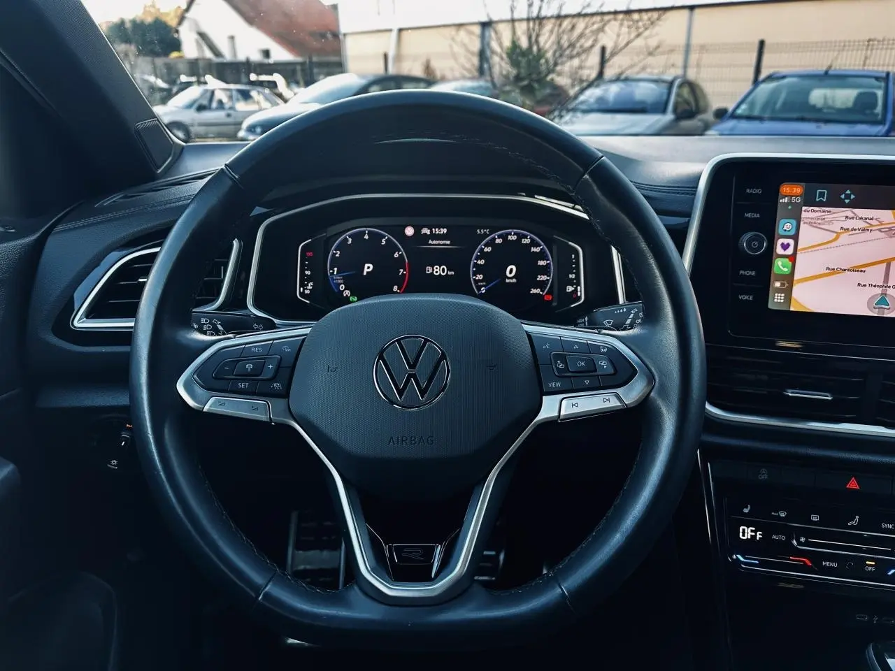 Vue frontale du volant cuir noir multifonction avec logo Volkswagen et tableau de bord digital du Volkswagen T-Roc 2024.