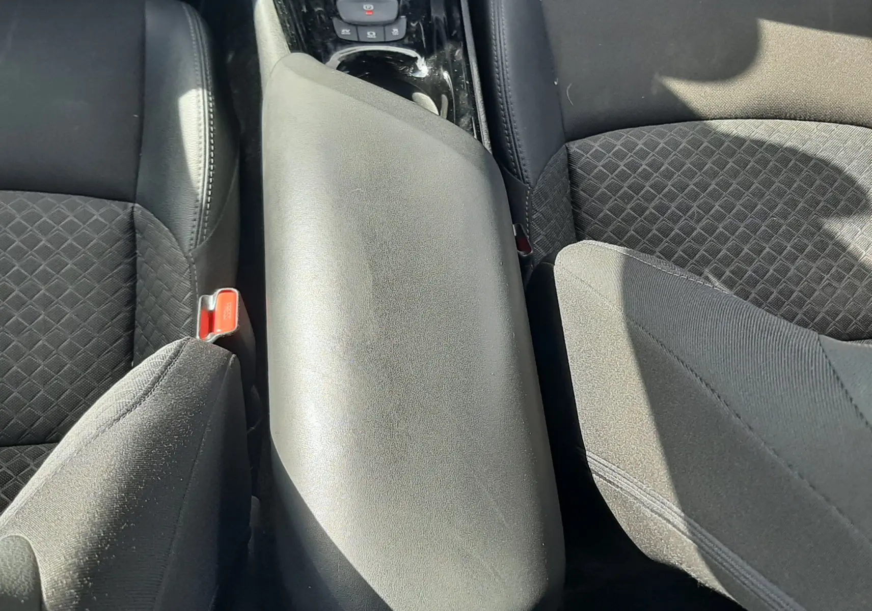Vue intérieure centrée sur le volant noir du Toyota C-HR 1.8 Hybrid 2023 avec tableau de bord et écran tactile visibles.