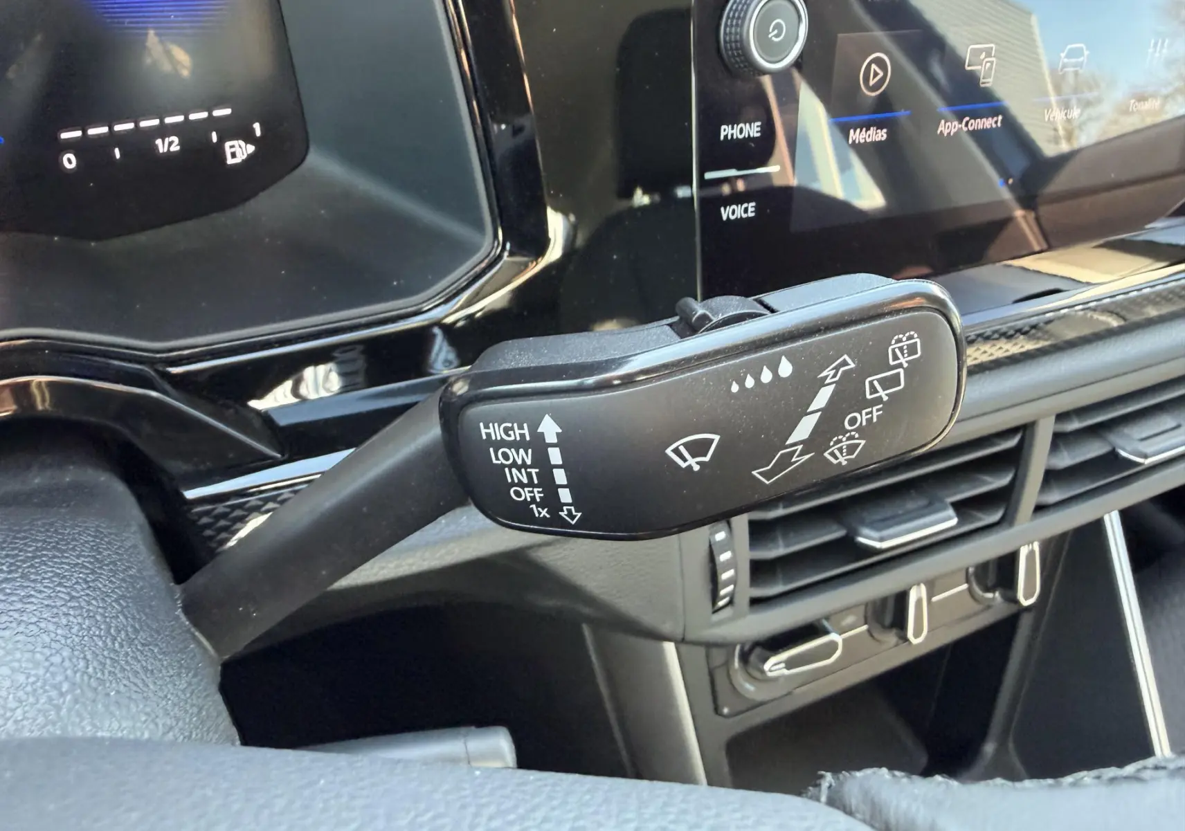 Gros plan sur la manette d’essuie-glace du Volkswagen Taigo 2025, avec tableau de bord et écran tactile en arrière-plan.
