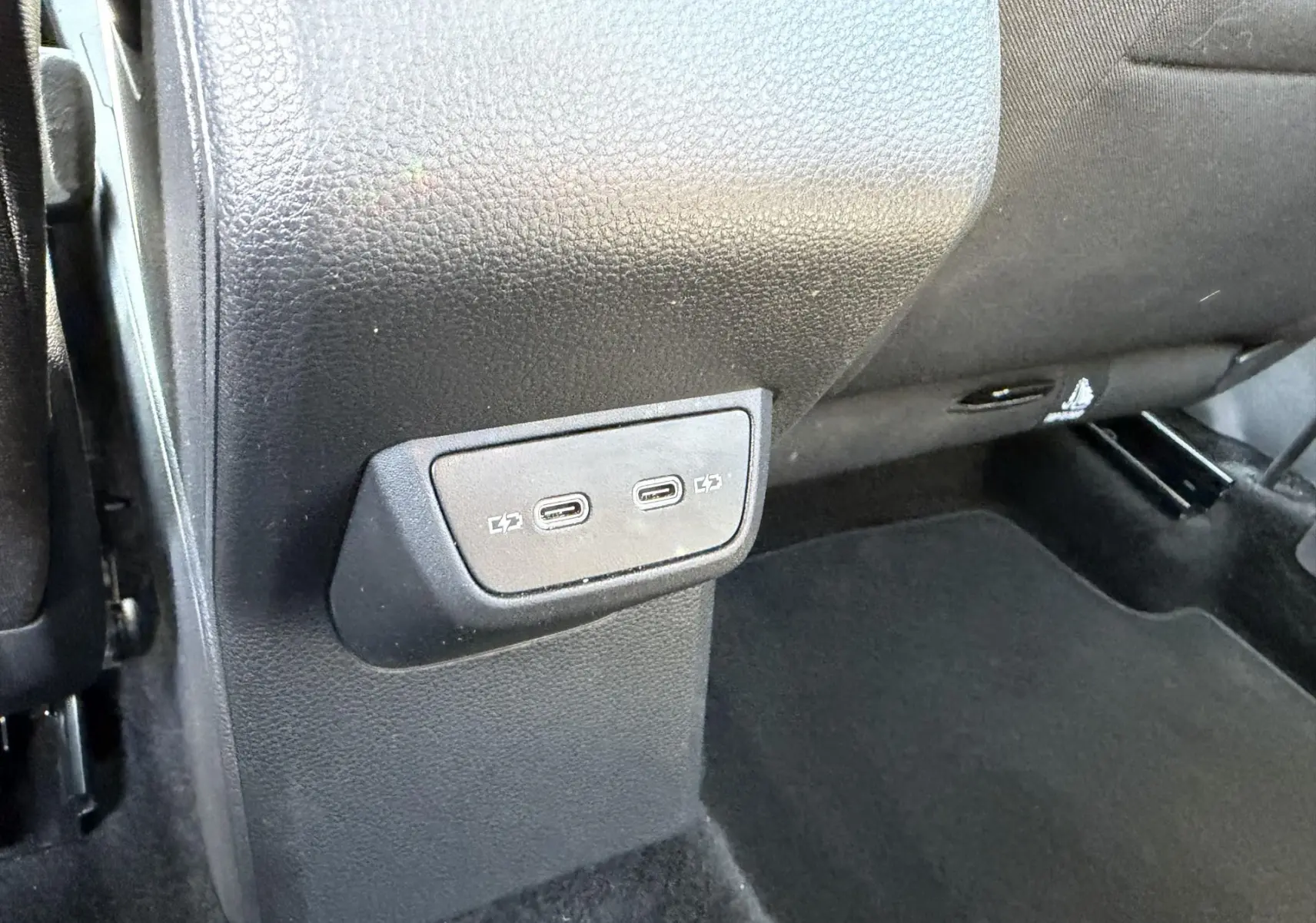 Prise USB-C double en bas de la console centrale arrière du Volkswagen Taigo 2025, intérieur noir.