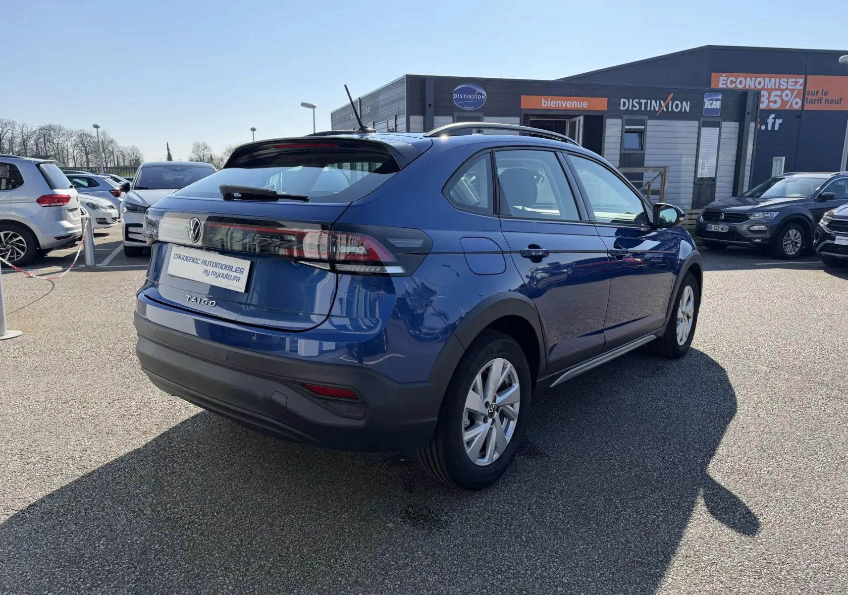 Vue 3/4 arrière droite d'un Volkswagen Taigo 2025 bleu métallisé avec jantes alliage et feux arrière LED.
