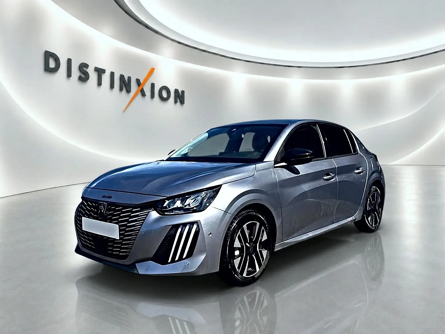 Peugeot 208 1.2 100 Allure gris Artense en 3/4 avant droit, avec calandre distinctive et jantes alu bicolores.