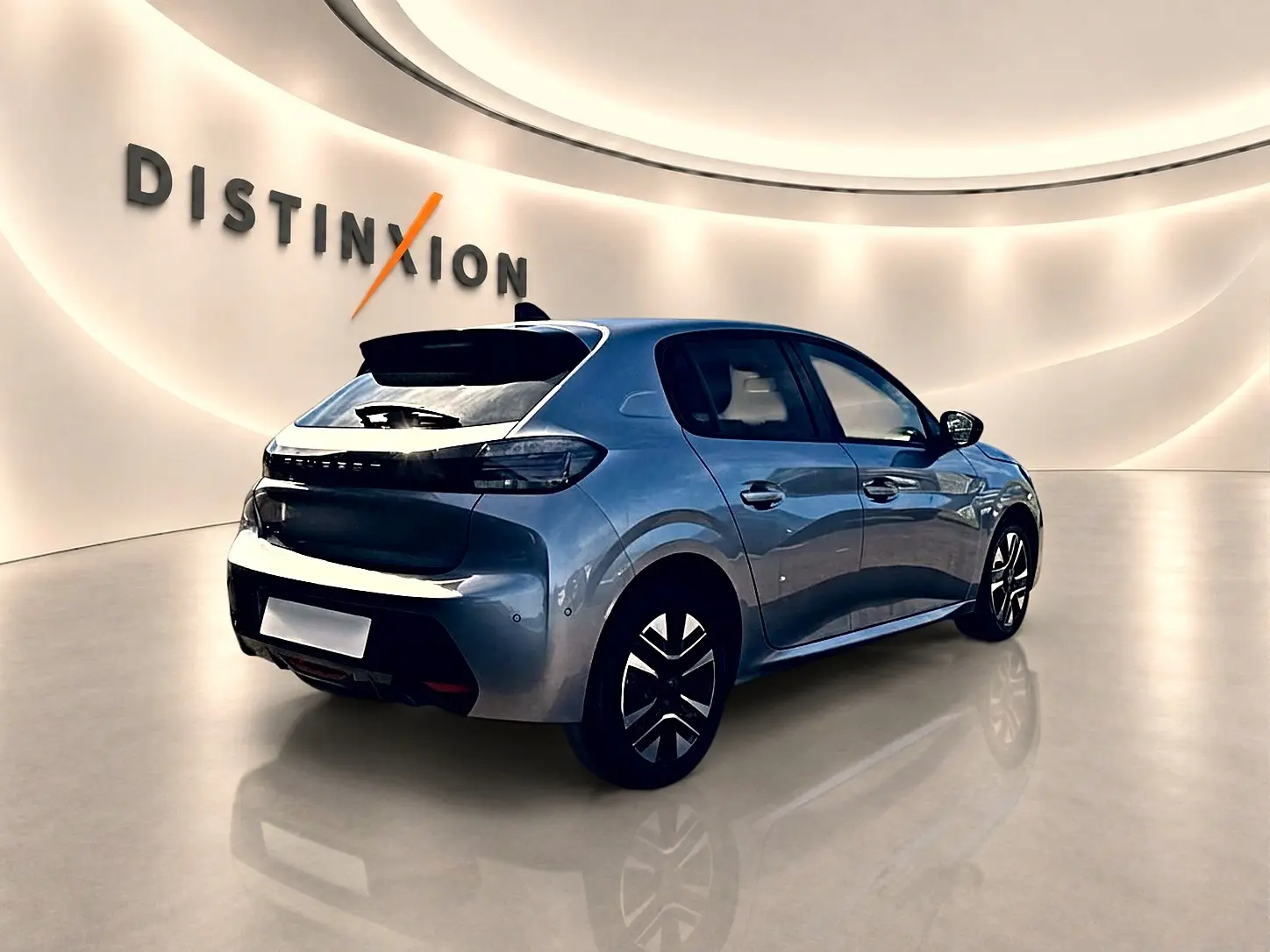 Peugeot 208 gris artense vue 3/4 arrière droit en intérieur avec jantes alu et feux arrière LED noirs.