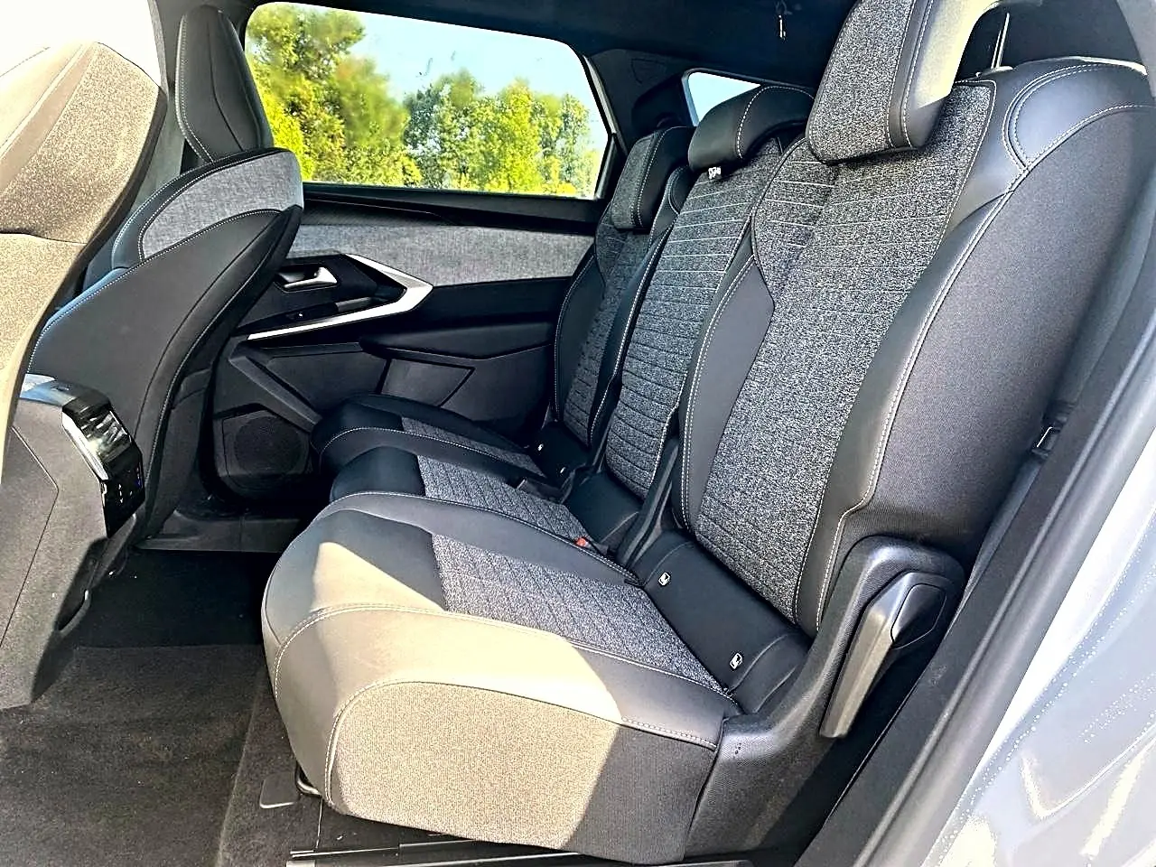 Vue latérale droite des sièges arrière en tissu gris et cuir noir du Peugeot 5008 Hybrid 145 allure e-dcs6 blanc.