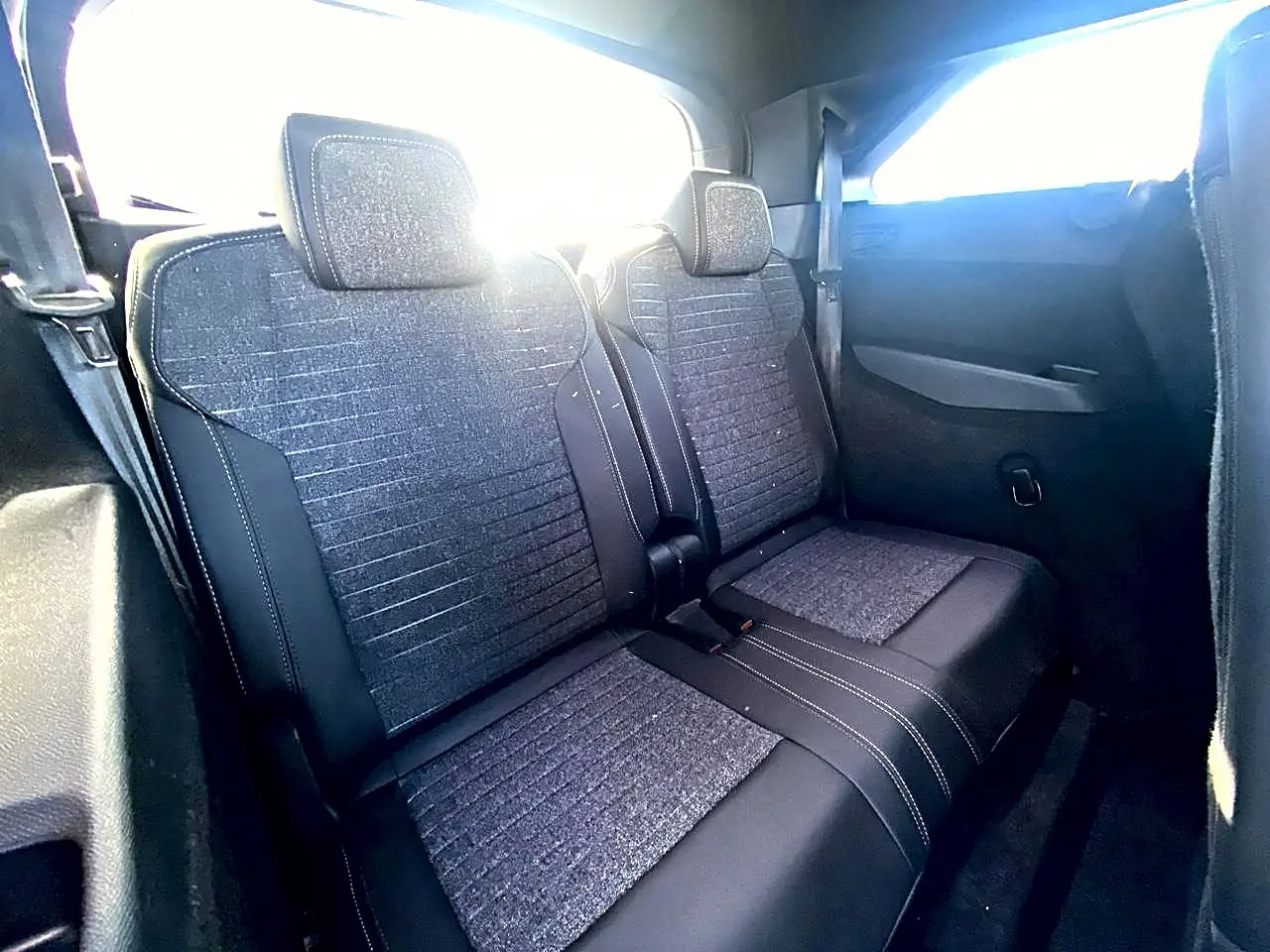 Vue intérieure montrant les deux sièges arrière supplémentaires en tissu gris et noir du Peugeot 5008 Hybrid 145 allure 2025.