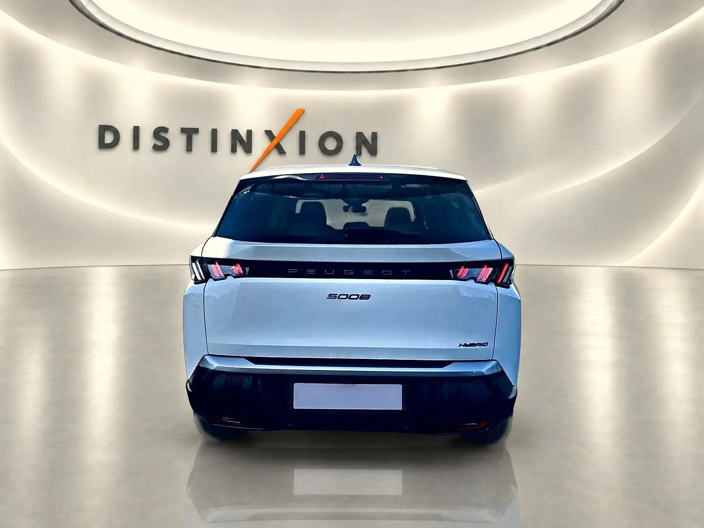 Vue arrière d'un Peugeot 5008 blanc hybride 2025 dans un showroom lumineux avec logo Distinxion en arrière-plan.