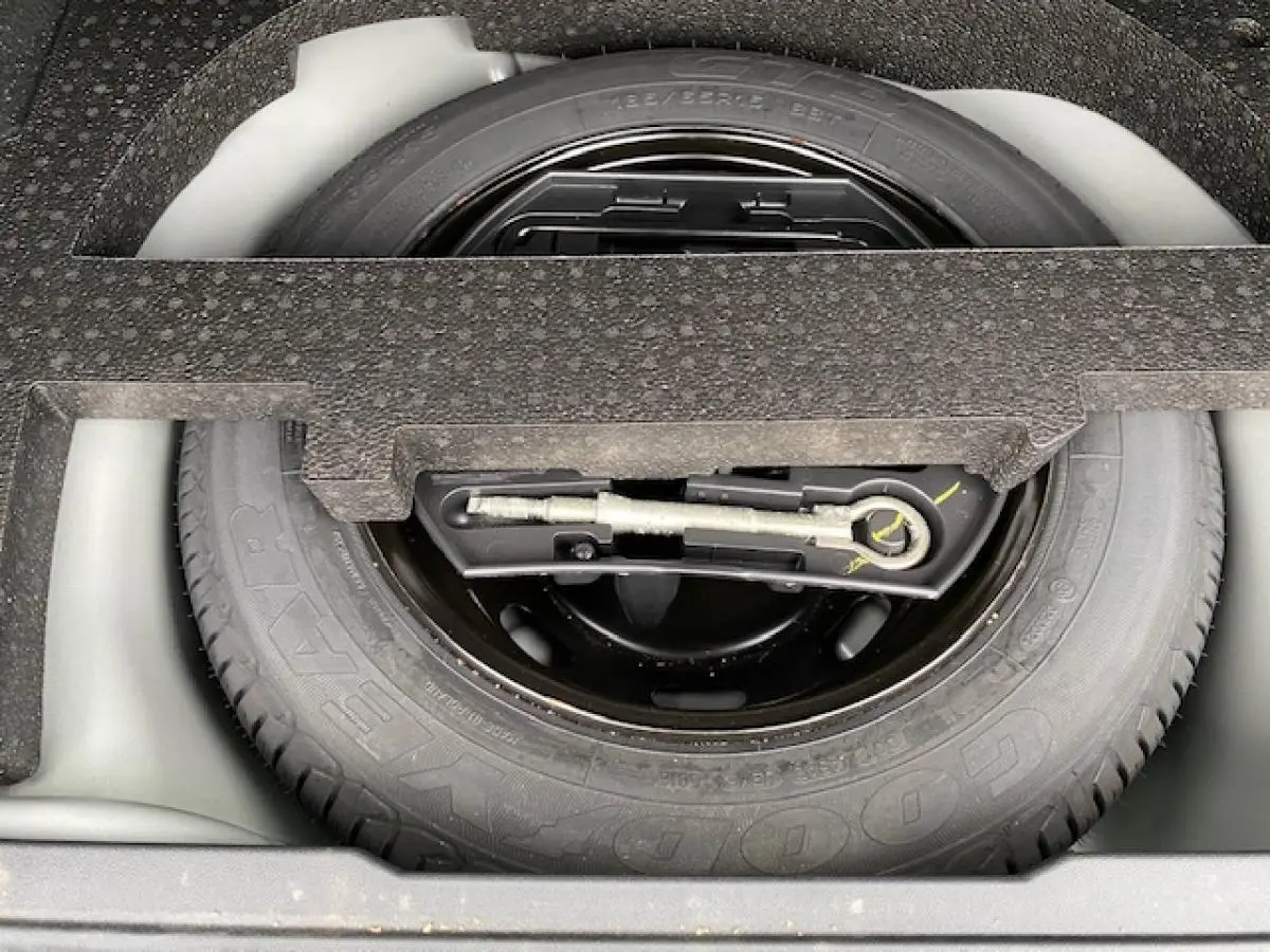 Gros plan sur la roue de secours en tôle noire du coffre du Peugeot 2008 gris foncé 2017.