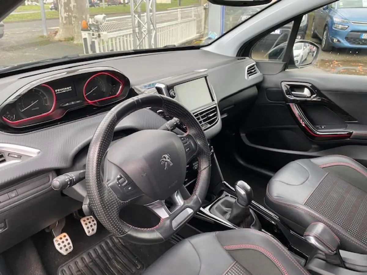 Intérieur de la Peugeot 2008 GT Line 2017, vue côté conducteur, volant cuir perforé et pédalier sport aluminium.