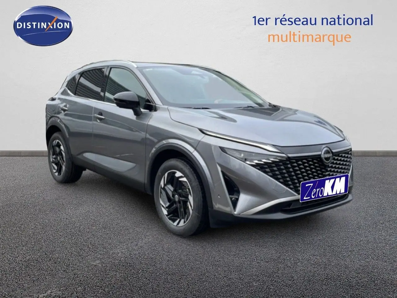 Vue 3/4 avant droit du Nissan Qashqai 2025 gris squale métal avec calandre noire et jantes stylisées.