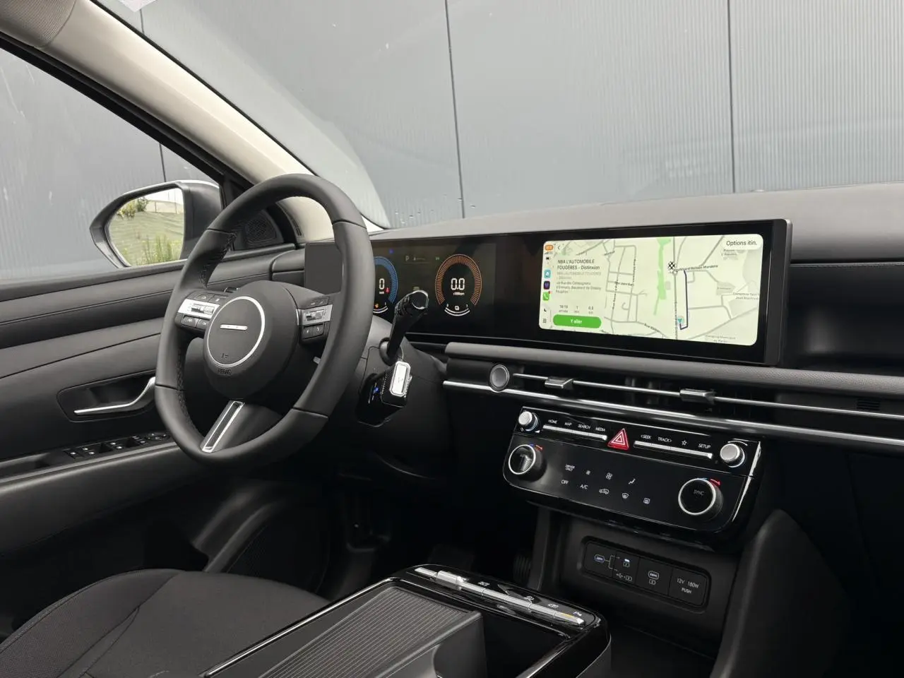 Vue intérieure côté conducteur du Hyundai Tucson blanc Serenity, avec tableau de bord numérique et écran tactile large.