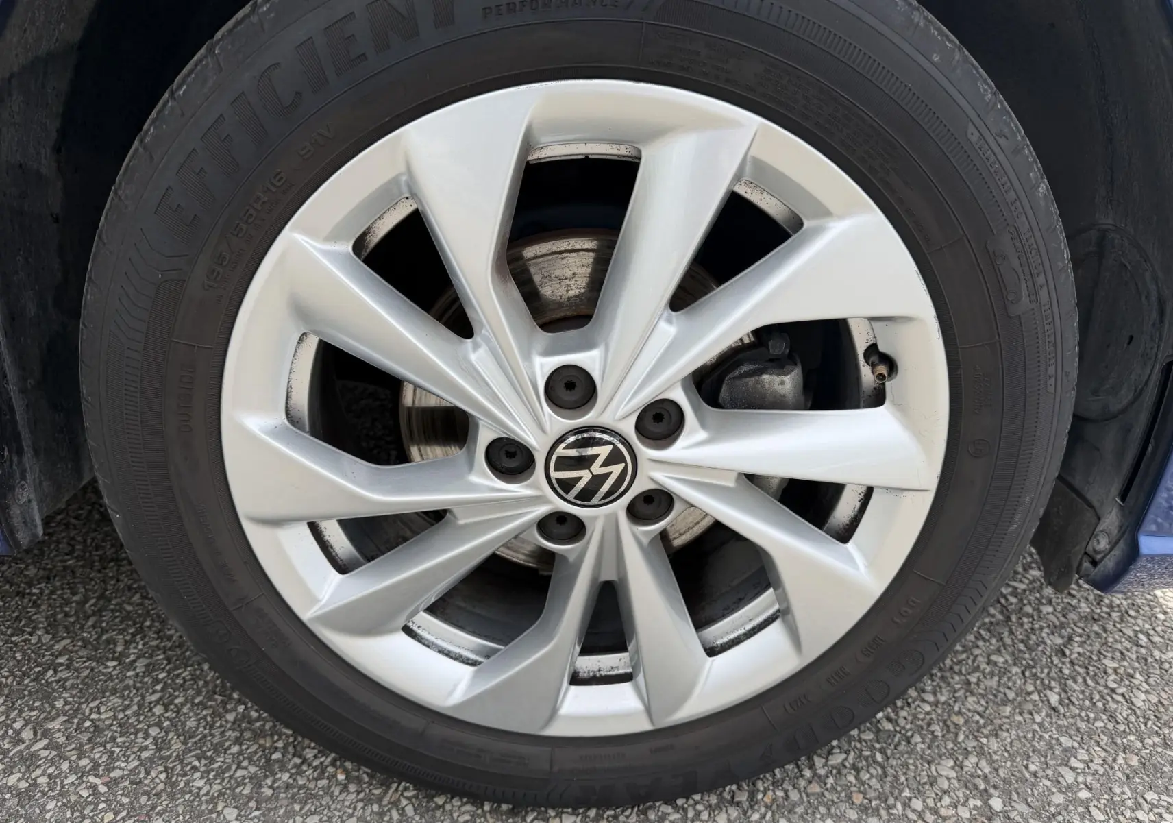 Gros plan sur la jante en alliage léger 16'' Palermo argentée de la Volkswagen Polo bleue, avec logo VW au centre.