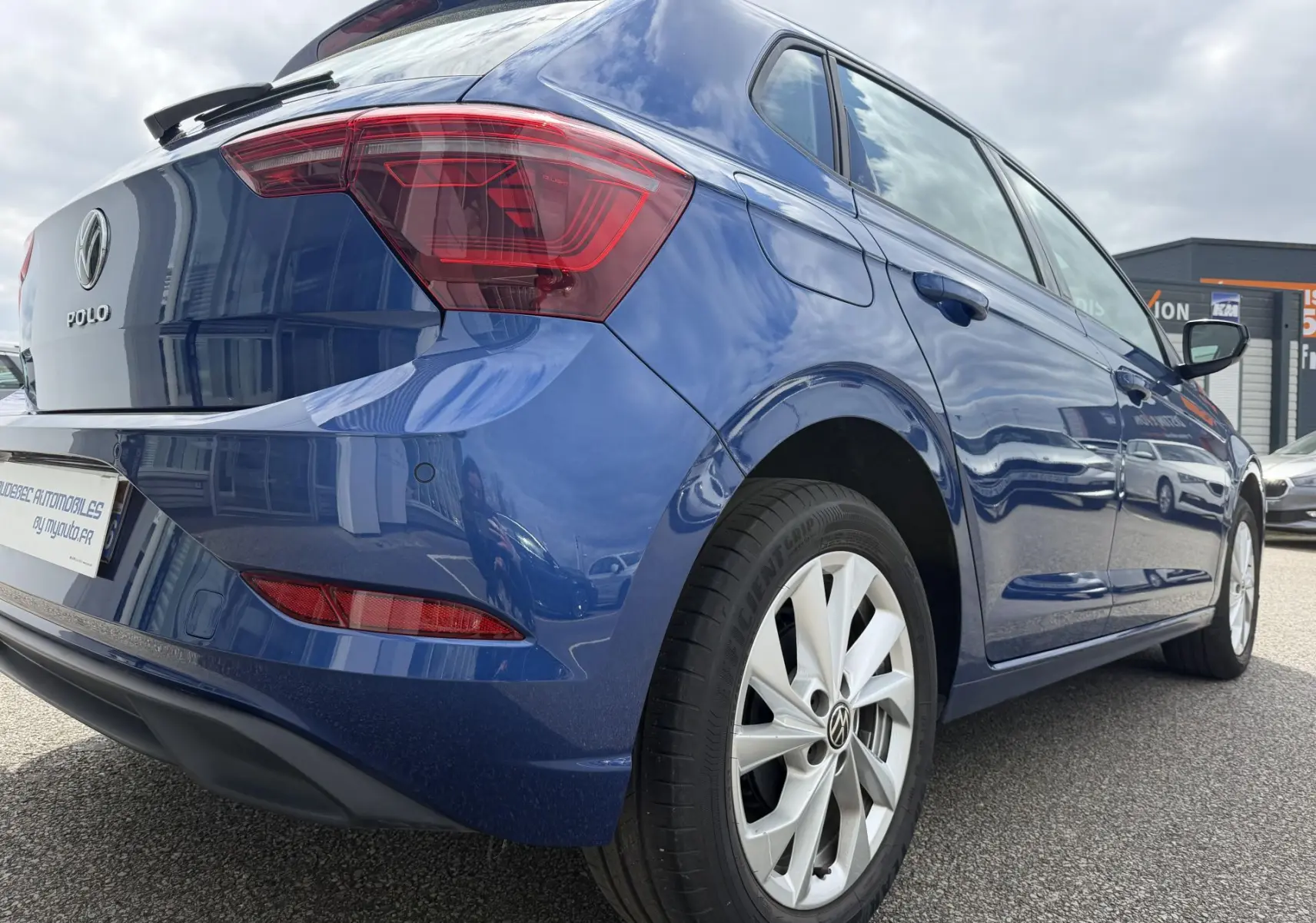 Vue 3/4 arrière droite d'une Volkswagen Polo bleue métallisée avec jantes alliage 16 pouces et feux arrière LED.