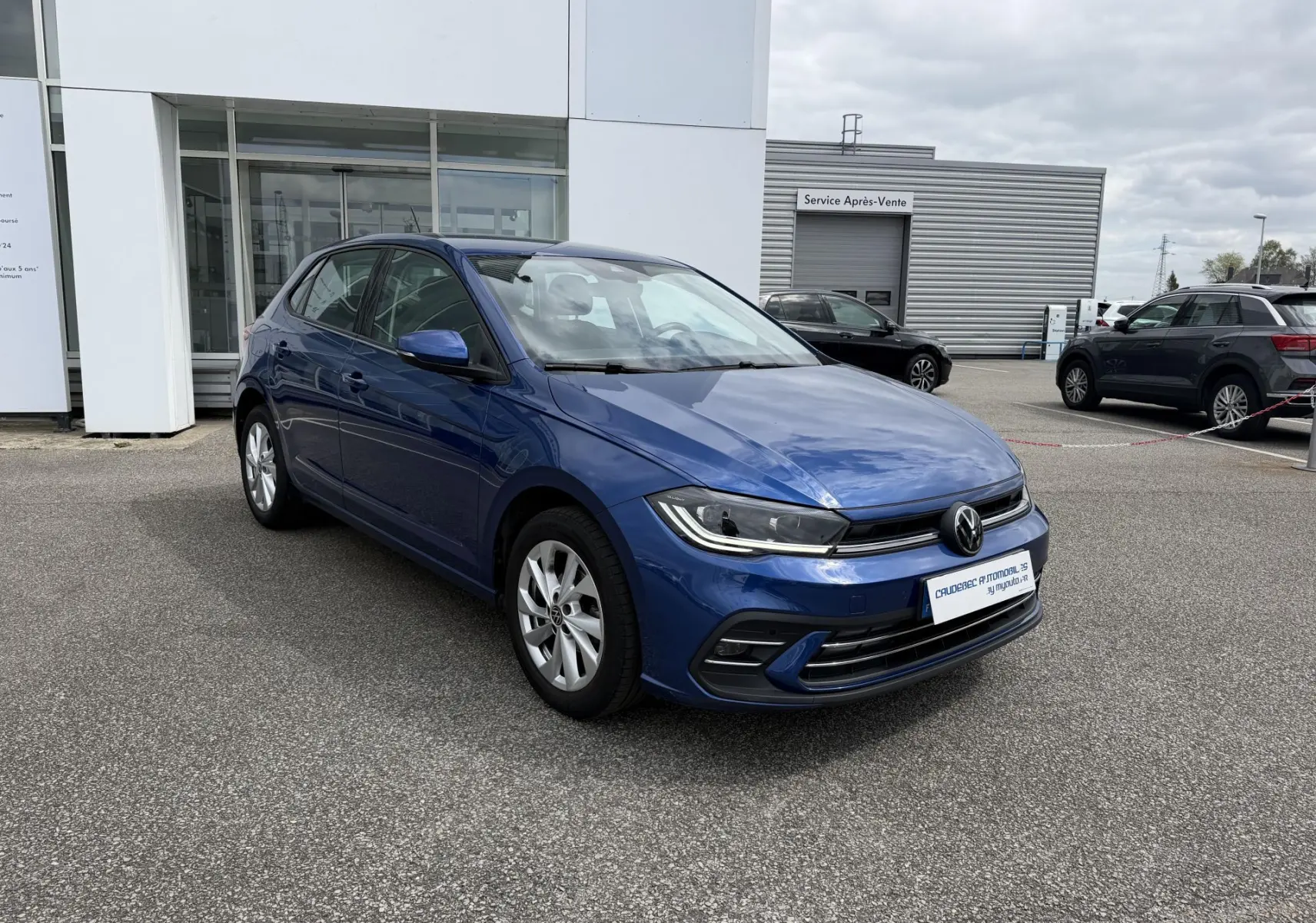 Volkswagen Polo bleue vue en 3/4 avant droit, avec jantes alliage et projecteurs LED allumés.
