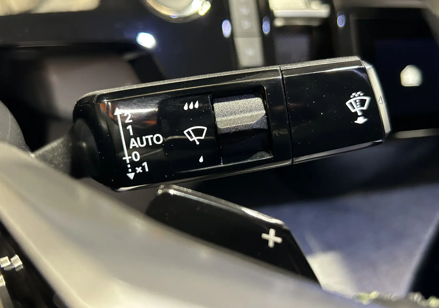Gros plan sur la commande de l’essuie-glace noir brillant dans l’habitacle du Peugeot 3008 Hybrid 2025.