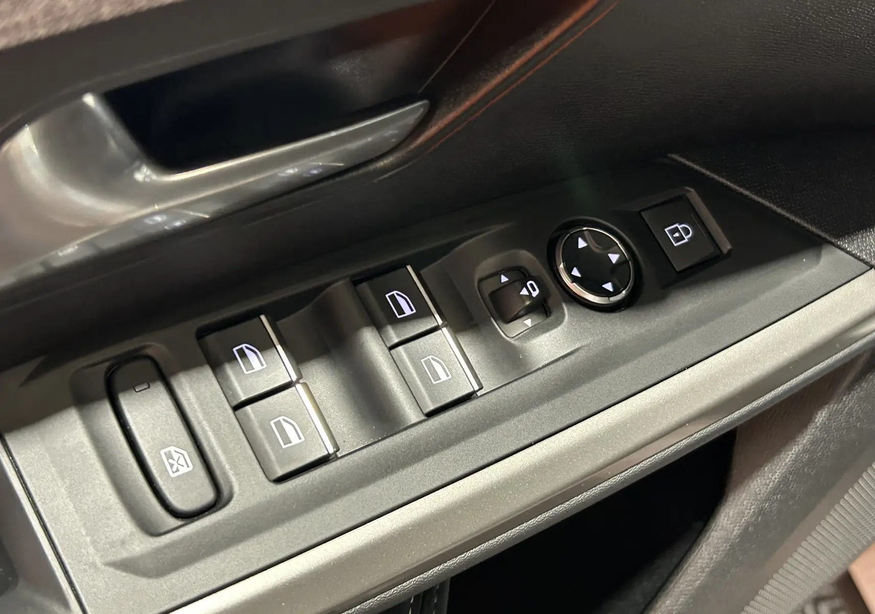 Gros plan sur les commandes de lève-vitres et rétroviseurs côté conducteur du Peugeot 3008 blanc Okenite, intérieur noir.