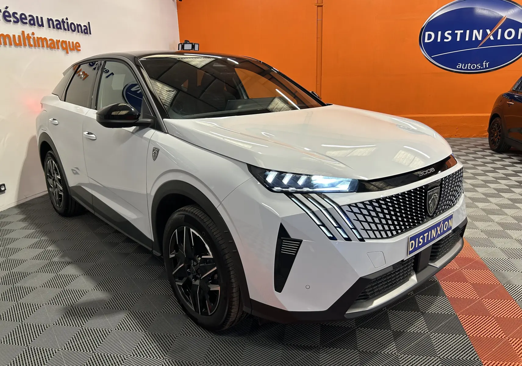 Peugeot 3008 III Hybrid blanc Okenite en 3/4 avant droit, avec calandre distinctive et feux LED allumés.