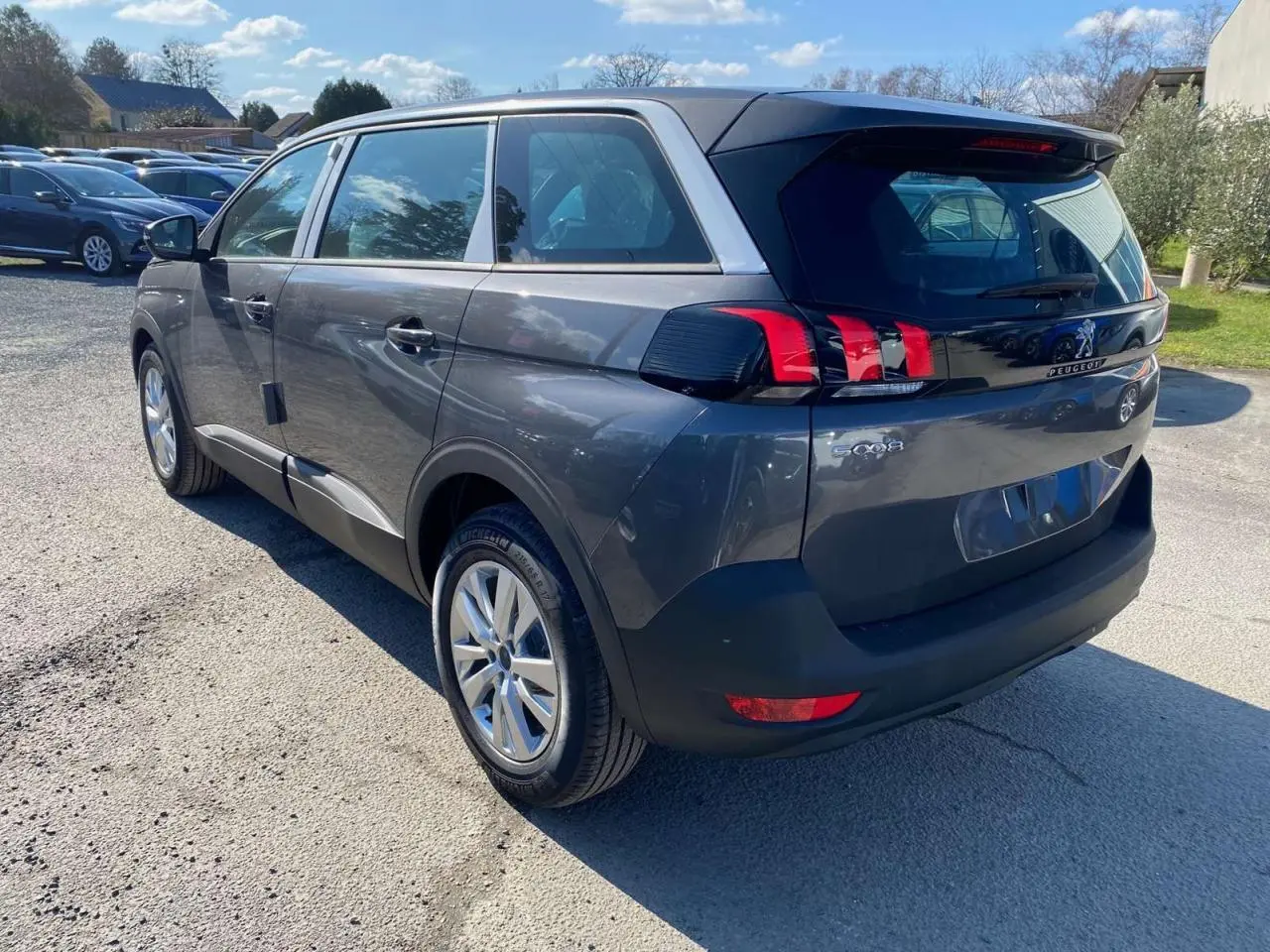 Vue 3/4 arrière droit du Peugeot 5008 gris platinium métallisé avec feux arrière LED et jantes alliage 17 pouces.