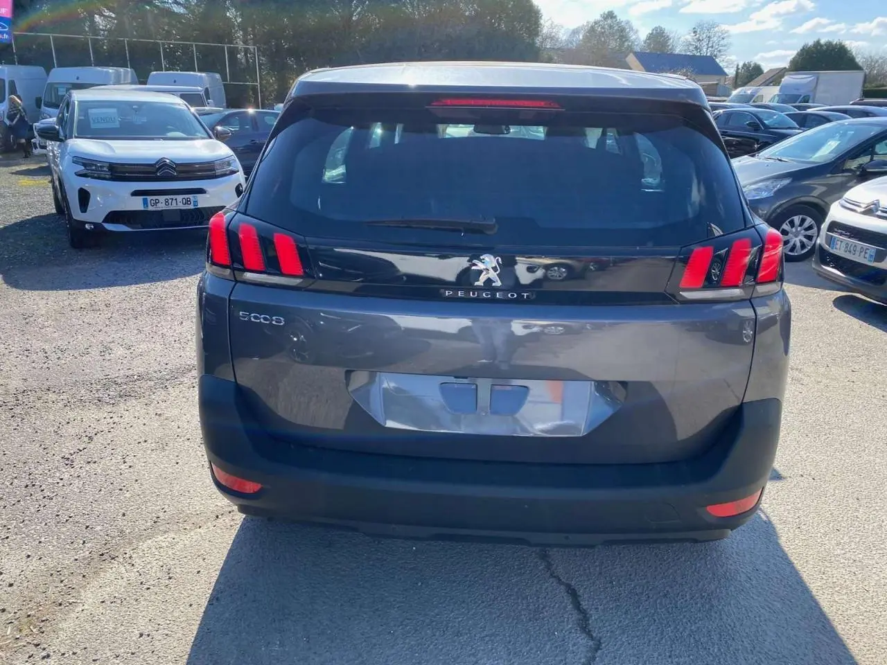 Vue arrière d'un Peugeot 5008 gris platinium métallisé avec feux arrière LED distinctifs en forme de griffes.