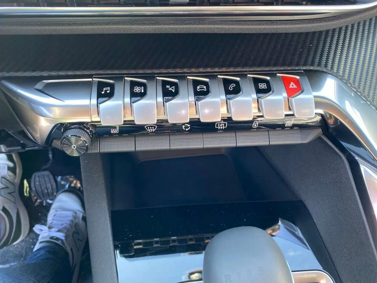 Gros plan sur la console centrale du Peugeot 5008 2023, montrant les touches piano chromées et le levier de vitesse.