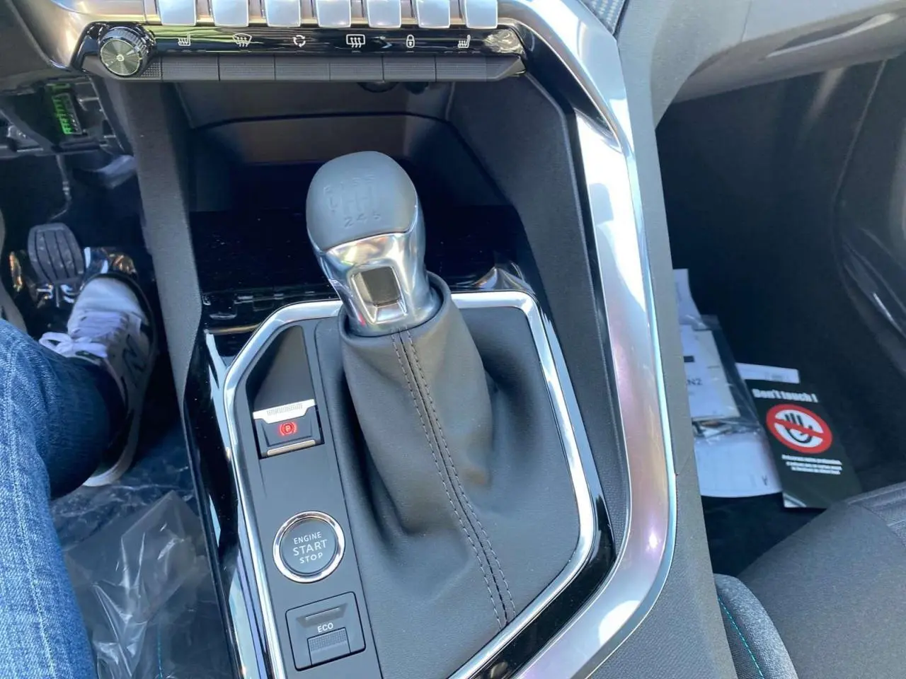 Gros plan sur la console centrale du Peugeot 5008 gris platinium, mettant en valeur le levier de vitesse manuel et le bouton start/stop.