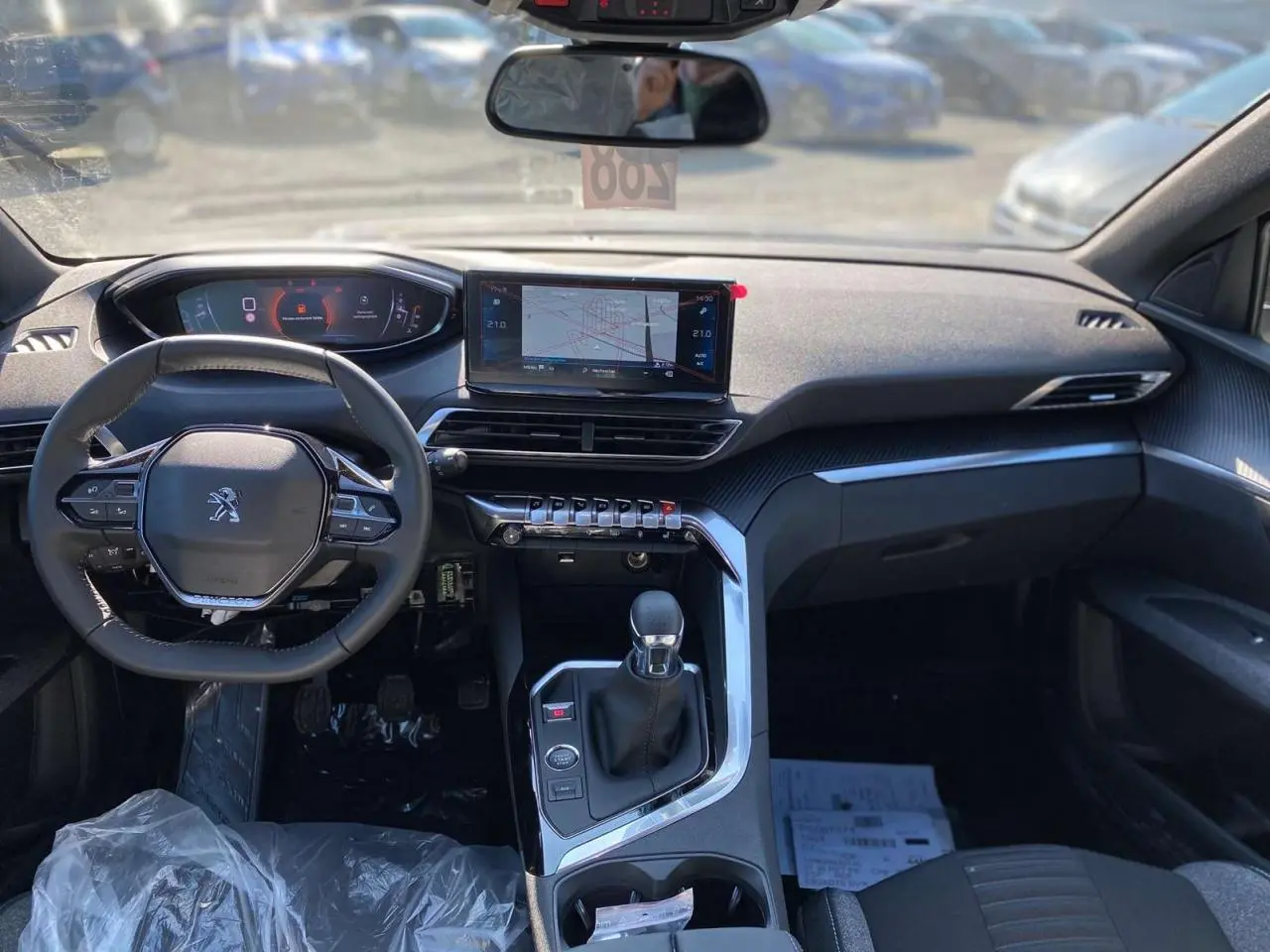 Vue intérieure du tableau de bord et volant compact Peugeot 5008 2023 avec écran tactile et levier de vitesses manuel.