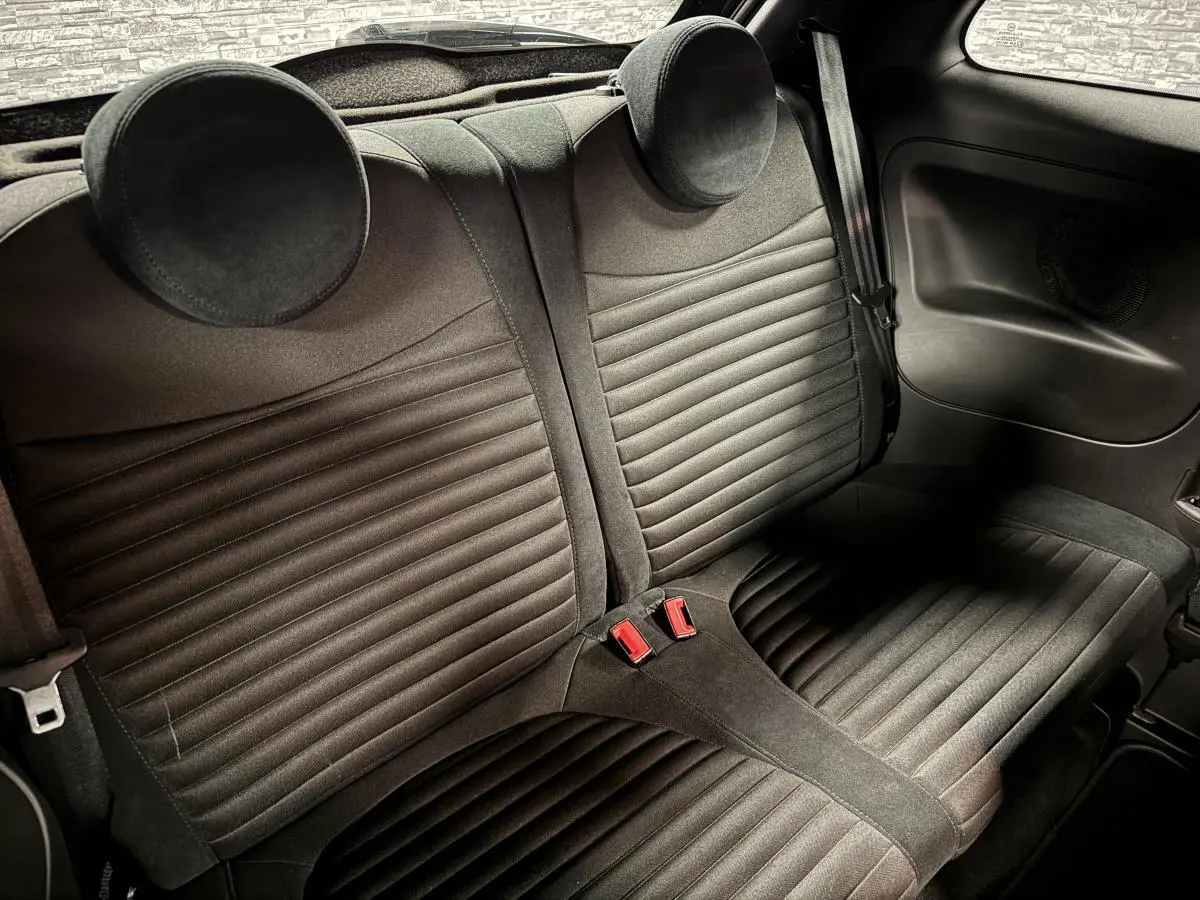 Vue intérieure de la banquette arrière en tissu noir de l'Abarth 595 Competizione 2022 avec appuie-têtes ronds.