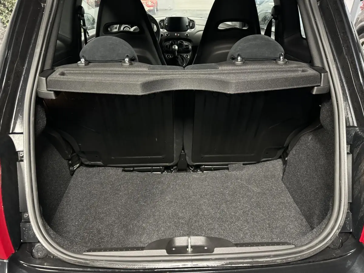 Coffre ouvert vu de l'arrière de l'Abarth 595 Competizione noire, montrant les sièges arrière et la tablette cache-bagages.