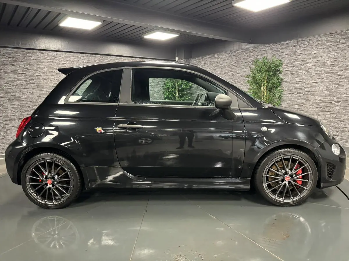 Profil côté gauche de l'Abarth 595 Competizione noire avec jantes alliage 17 pouces et étriers Brembo rouges.