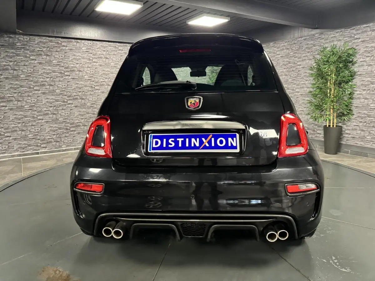 Vue arrière d'une ABARTH 595 noire avec quadruple sortie d'échappement chromée et feux arrière LED rouges.
