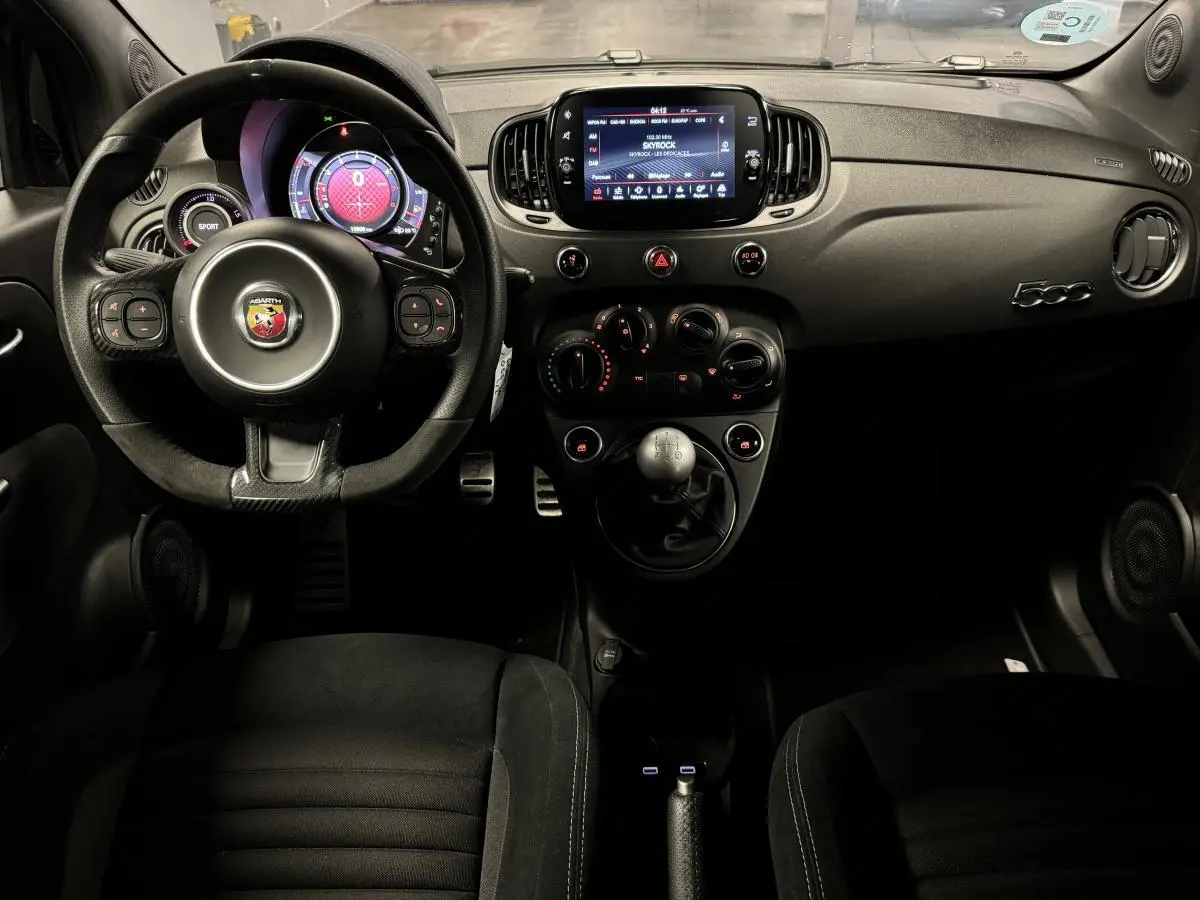 Intérieur de l'Abarth 595 Competizione 2022 vu de face, volant cuir/alcantara, écran tactile 7'', levier de vitesses manuel.