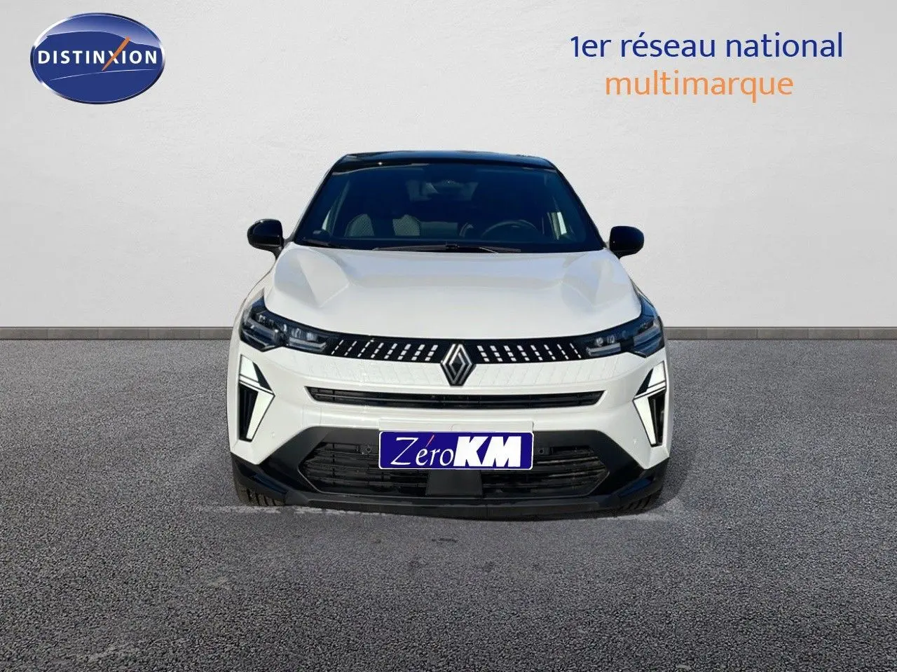 Vue avant d'un Renault Captur E-Tech hybride blanc nacré avec toit noir, mettant en valeur sa calandre moderne et ses phares LED.