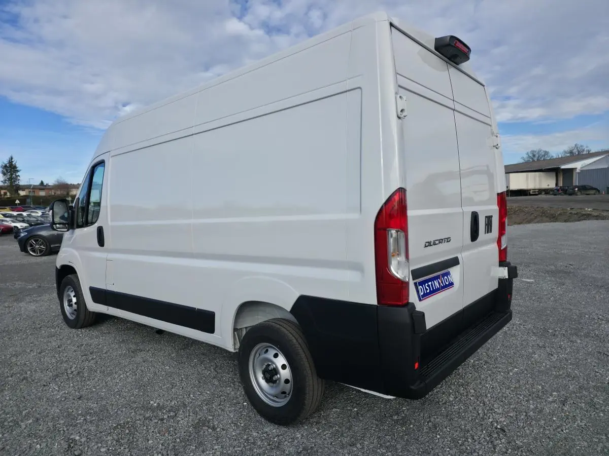 Fiat Ducato Fourgon blanc vu en 3/4 arrière droit, avec portes arrière tôlées et roues acier 15 pouces.