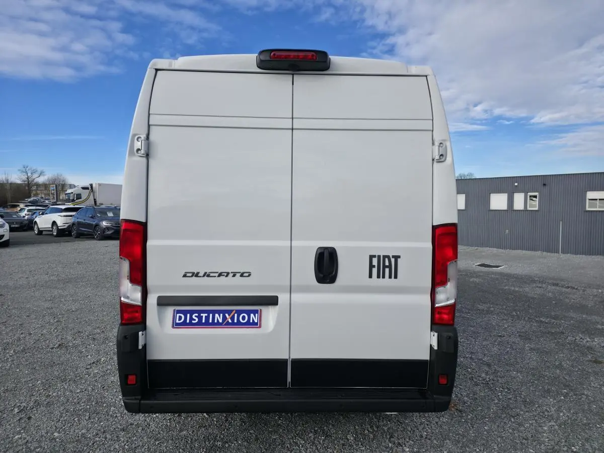 Vue arrière d’un fourgon FIAT Ducato blanc 2025 avec portes battantes et feux rouges verticaux.