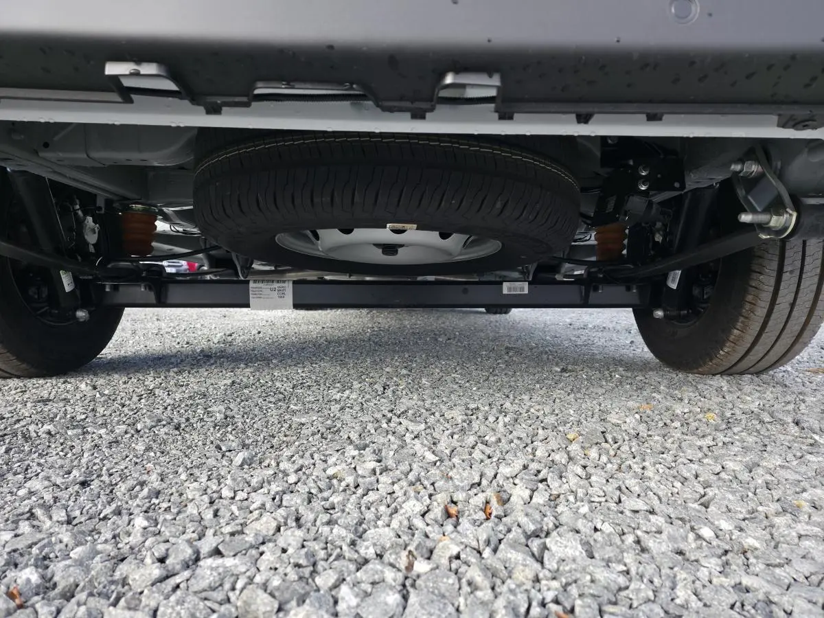 Vue en contre-plongée sous le FIAT Ducato Fourgon blanc 2025, mettant en valeur la roue de secours sous le châssis.
